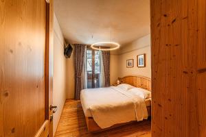 a small bedroom with a bed and a window at Chalet Meridiana in Bormio