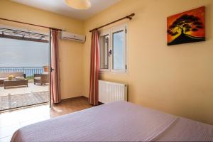 a bedroom with a bed and a large window at Aphrodite Blue in Trapezaki +27 photos