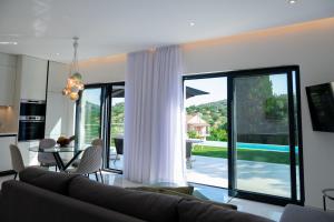 a living room with a couch and a table at Villa Rinoula-private pool in Vitalades