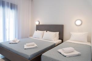 two beds in a room with towels on them at Villa Rinoula-private pool in Vitalades +34 photos