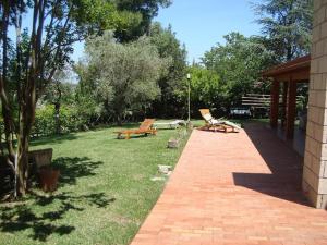 two benches sitting on a lawn with a pavilion at La Favola Verde in Roccadaspide