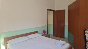 a bedroom with a white bed and a cabinet at Appartamenti Don Guglie' in Cetraro