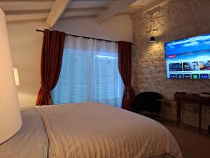 a bedroom with a bed and a flat screen tv at Casa Oksana in Castelnau-de-Montratier