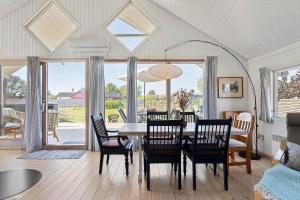 a dining room with a table and chairs and a large window at FY222-Otterup-Klovervaenget-13 in Otterup