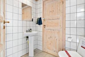 a bathroom with a sink and a wooden door at FY222-Otterup-Klovervaenget-13 in Otterup +32 photos