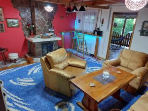 a living room with couches and a table and a fireplace at FortUNA Holiday Home in Bihać