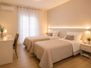 a hotel room with two beds and a window at IL CENTRO rooms in Cerignola