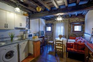 a kitchen and living room with a table and a kitchen and a dining room at Apartamentos Rurales Tía Josefa in Tornavacas