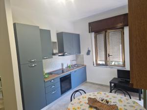 a kitchen with blue cabinets and a table at Appartamenti Don Guglie' in Cetraro +18 photos
