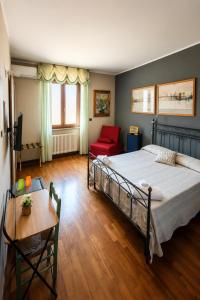 a bedroom with a large bed and a red chair at La quercia di Massena in Lauria Inferiore