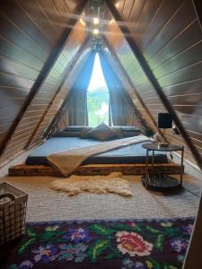 a bedroom with a bed in a tent at Maria's Cabin & Spa in Băiaşu