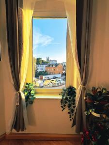 a window with curtains and a view of a city at Pension J&M in Meißen