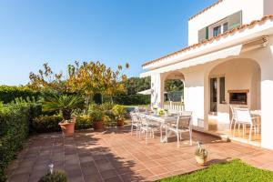 a patio of a house with a table and chairs at Estrella Del Mar with Private Pool in Binibeca