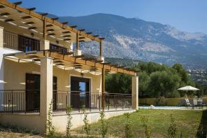 a house with a balcony with a view of a mountain at Villa Karavias by Villa Select in Trapezaki