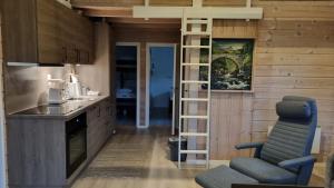 a kitchen with wooden walls and a staircase in a room at Brudevoll Gard in Ørsta