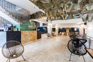 a lobby with chairs and a bar with a stone wall at Imperial Hotel&Spa - Baile Olanesti in Băile Olăneşti