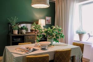 a dining room with a table with a green wall at Tajna Bazia in Nidzica