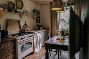 a kitchen with a stove and a table with a dining room at Tajna Bazia in Nidzica +33 photos