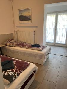 two beds sitting in a room with windows at Pensili Apartmanház Balatonfüred in Balatonfüred