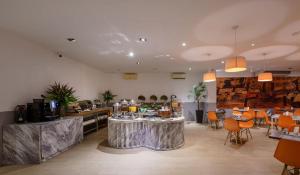 a restaurant with tables and chairs in a room at The Grand Palm Villa in Ban Bang Phrao