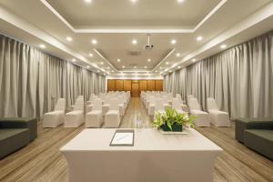 a conference room with a table and white chairs at The Grand Palm Villa in Ban Bang Phrao