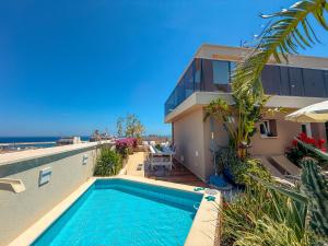 a villa with a swimming pool in front of a house at Sky Garden - luxury suite in Monopoli