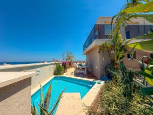 a house with a swimming pool next to the ocean at Sky Garden - luxury suite in Monopoli
