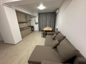 a living room with a couch and a kitchen at Apartament Meraki Resort&Spa in Năvodari +4 photos