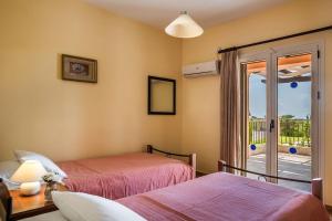 a bedroom with two beds and a balcony at Athina Rose in Trapezaki +19 photos
