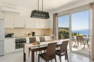 a kitchen with a table and chairs and a large window at Lourdas Sunshine in Lourdata