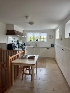 a kitchen with a table in the middle of it at Gorse cottage in Newton Abbot +16 photos