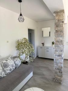 a living room with a couch and a stone pillar at Fortress Apartment in Bar