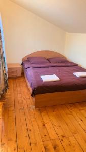 a bed in a bedroom with a wooden floor at Stara Praha Loft Rooms in Uzhhorod