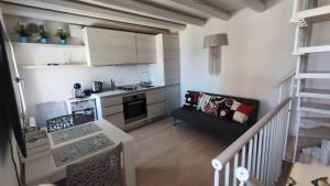 a small kitchen and living room with a couch at Lagunahome Beatrice in Chioggia