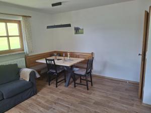a dining room with a table and chairs and a couch at Bio Berghof Langerlehen in Berchtesgaden