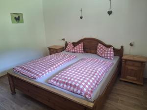 a bed with red and white sheets and pillows on it at Bio Berghof Langerlehen in Berchtesgaden