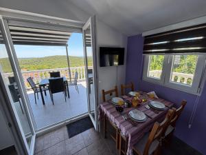 a dining room with a table and a balcony at Apartmani Suzanna, apartman a in Eraci