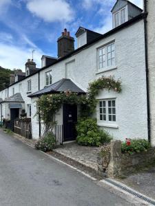 a white house with flowers on the side of it at Gorse cottage in Newton Abbot