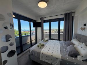 a bedroom with a large bed with a large window at Киво апарт Созопол in Sozopol +48 photos