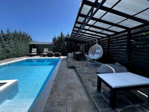a swimming pool with a pergola and a patio with a table at Two Bedroom Villa with Private Pool & Garden by Olivujoj in Anavyssos