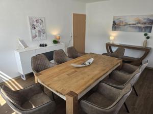 a dining room with a wooden table and chairs at Ferienhaus am Bethlehem Kanal in Papenburg