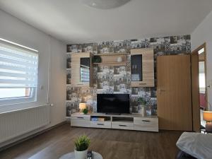 a living room with a television on a cabinet at Ferienhaus am Bethlehem Kanal in Papenburg