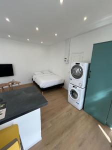 a small room with a bed and a washing machine at L'Echappée Verte Climatisée in Marvejols