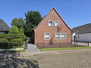 a brick house with a fence in front of it at Ferienhaus am Bethlehem Kanal in Papenburg