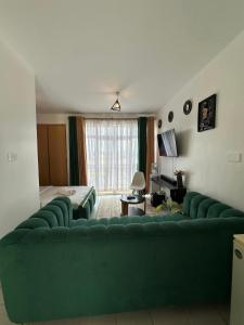a living room with a large green couch in a room at Luxe Haven in Nairobi
