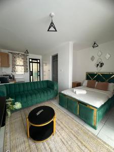 a living room with a green couch and a bed at Luxe Haven in Nairobi