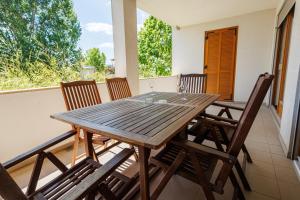 a wooden table and chairs on a balcony at Jacht Apartmanok in Balatonfüred