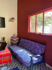 a living room with a purple couch and a window at Le Poulagou in Saint-Louis