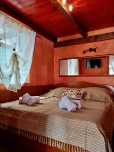a bedroom with a bed with two pillows and a window at Vila s bazenom Mavrinac in Nerezine +13 photos