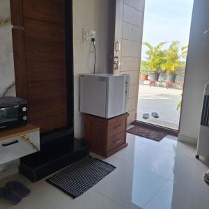 a room with a refrigerator on top of a wooden cabinet at Aavasan home stay with AC in Dāvangere